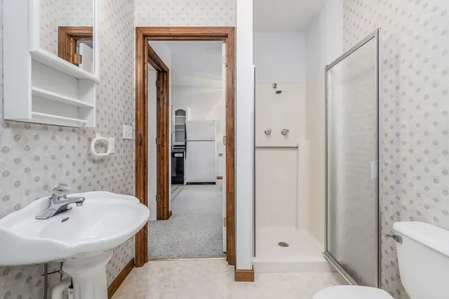 a bathroom with a sink a toilet and shower