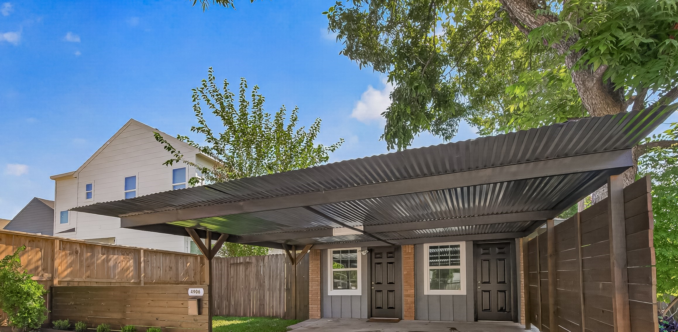 103 East Janisch Road Houston, TX 77022 - Photo 16 of 27 Home number 2 has 1 bedroom and 1 bath with large yard space. This home offers a spacious carport with a modern corrugated metal roof provides ample covered parking, complemented by a surrounding privacy fence and mature trees for shade.