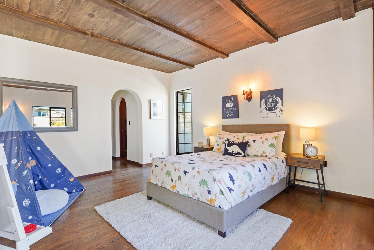 401 Parrott Drive San Mateo, CA 94402 - Photo 45 of 68 a bedroom with a large bed and a wooden floor