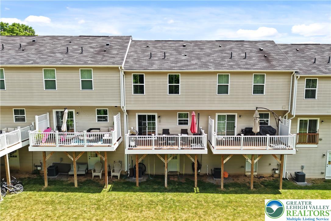 2336 Alex Road Easton, PA 18040 - Photo 28 of 35 Attached wooden decks with white railings overlook a green lawn, offering private outdoor retreats for each unit.