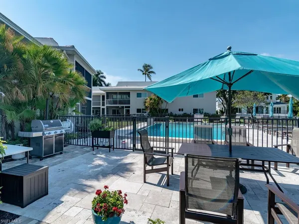a patio with glass top table and chairs