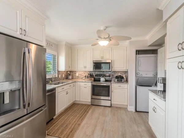 a kitchen with white cabinets and stainless steel appliances