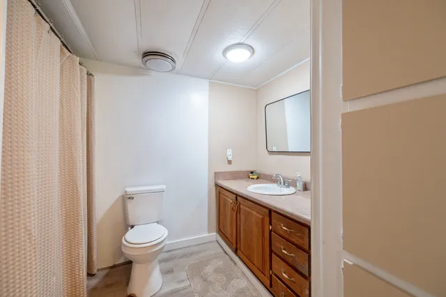a bathroom with a toilet sink a mirror and vanity
