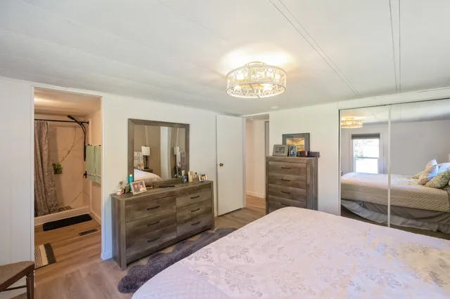 a view of a bedroom with cabinet mirror and windows