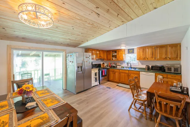 a living room with stainless steel appliances furniture and a kitchen view