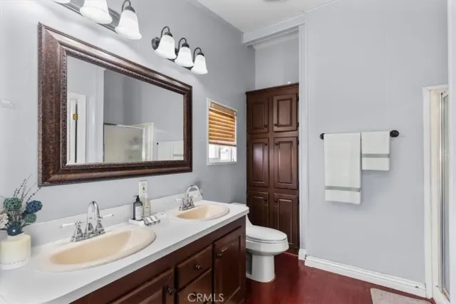 a bathroom with a toilet sink double vanity and mirror