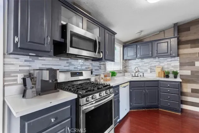 a kitchen with stainless steel appliances a stove microwave and sink