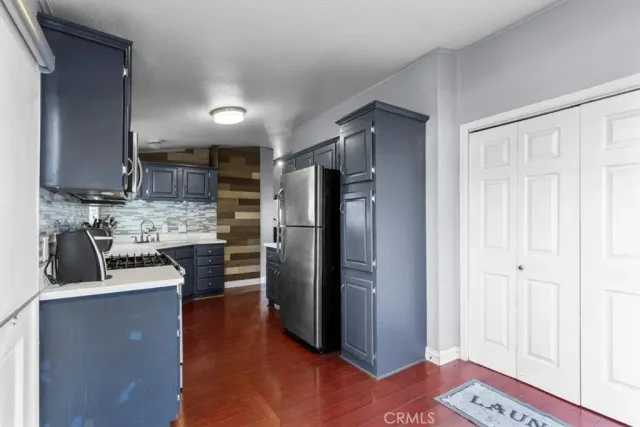 a kitchen with stainless steel appliances granite countertop a refrigerator and a stove top oven