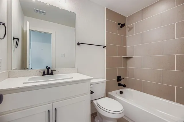 a bathroom with a sink toilet vanity and shower