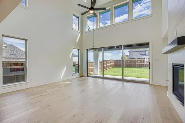 a view of an empty room with wooden floor and a fireplace