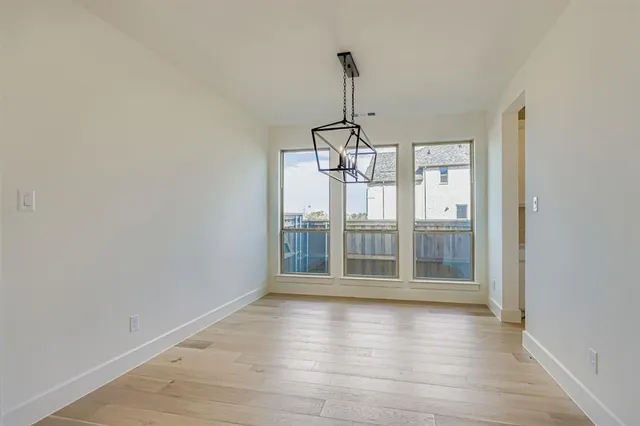 a view of a room with wooden floor chandeliers and kitchen