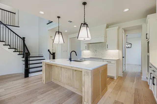 a kitchen with sink stove and white cabinets