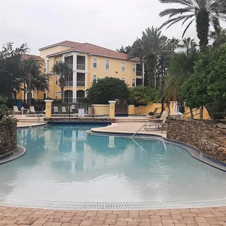 a view of a house with pool and chairs