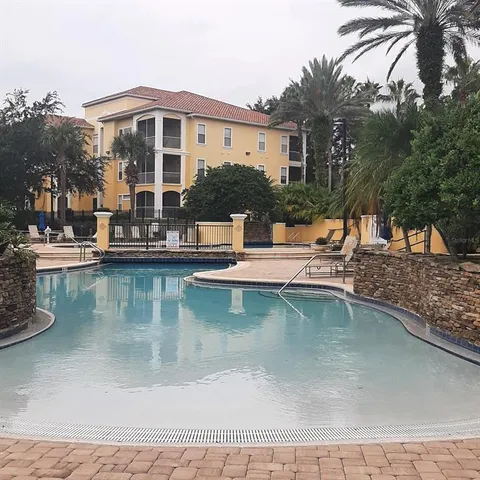 a view of a house with pool and chairs
