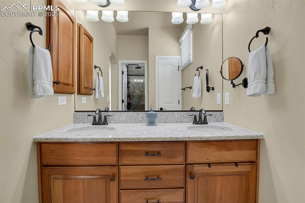 13015 Cake Bread Heights Colorado Springs, CO 80921 - Photo 19 of 45 a bathroom with a granite countertop sink a mirror and shower