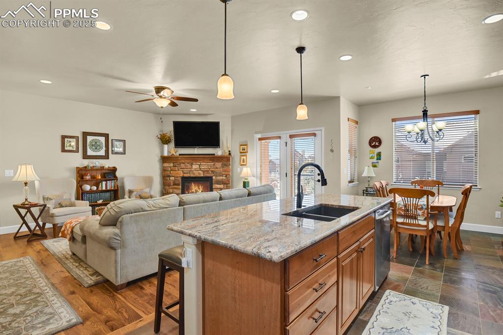 13015 Cake Bread Heights Colorado Springs, CO 80921 - Photo 5 of 45 a living room with fireplace a dining table and a chandelier