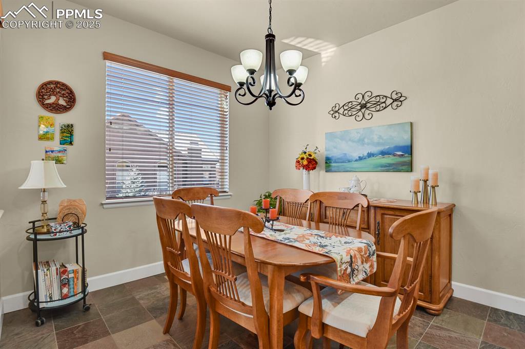 13015 Cake Bread Heights Colorado Springs, CO 80921 - Photo 8 of 45 a view of a dining room with furniture wooden floor and a chandelier