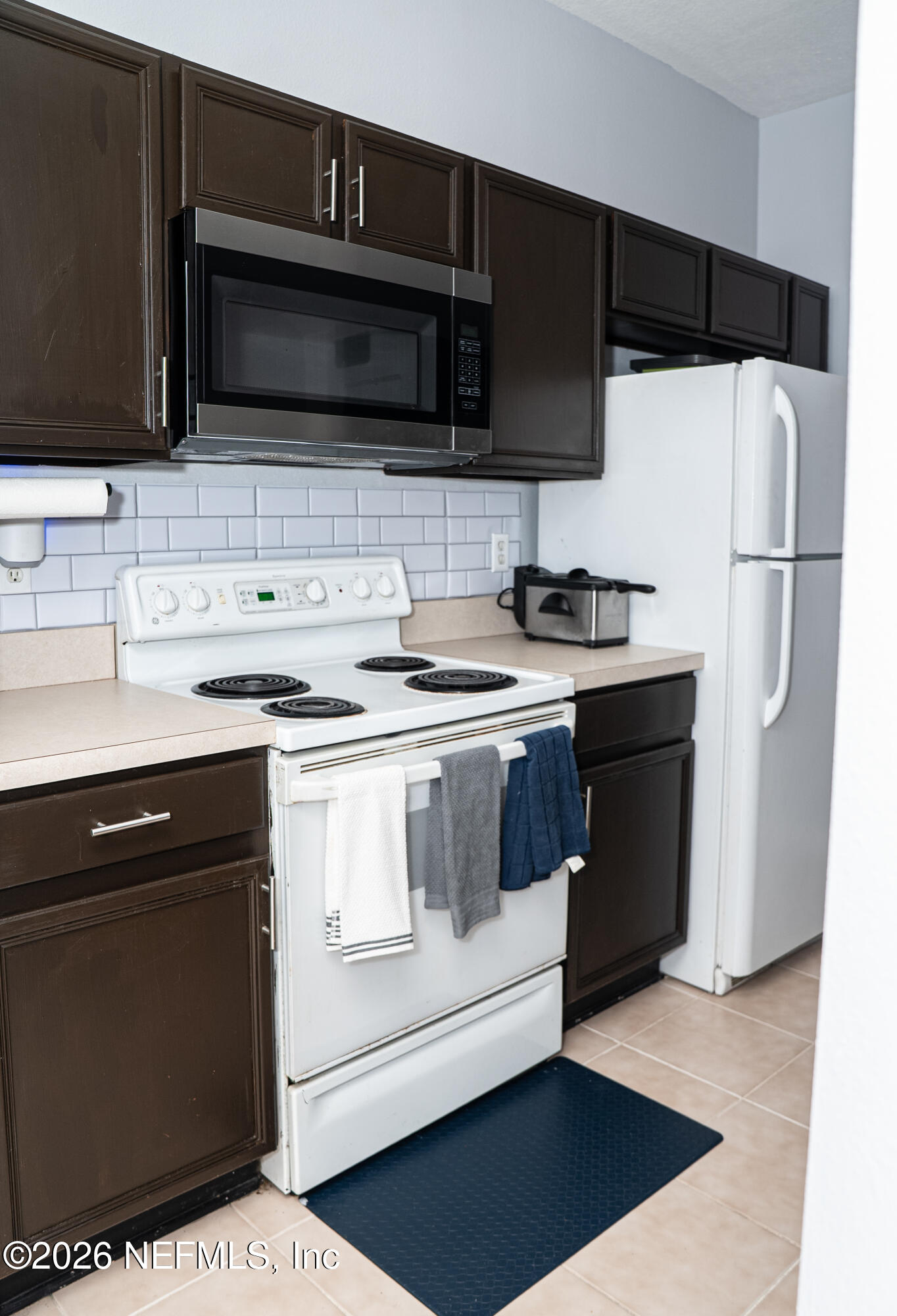 7990 Baymeadows Road East, Unit 530 Jacksonville, FL 32256 - Photo 5 of 19 a kitchen with stainless steel appliances a stove a microwave a sink and cabinets