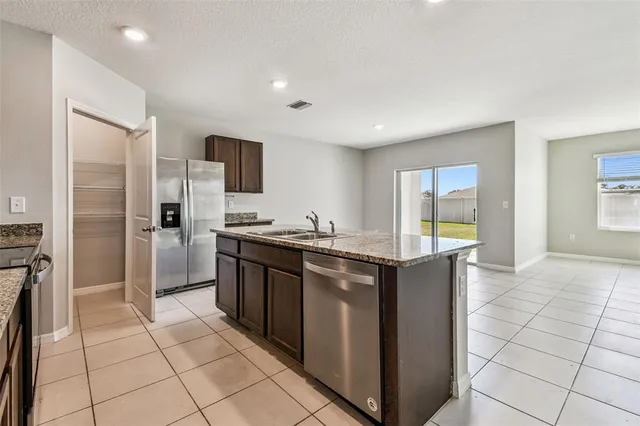 a kitchen with stainless steel appliances granite countertop a stove top oven a sink a counter top space and cabinets