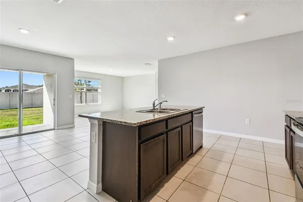 a view of kitchen with stainless steel appliances granite countertop a stove top oven a sink and a microwave
