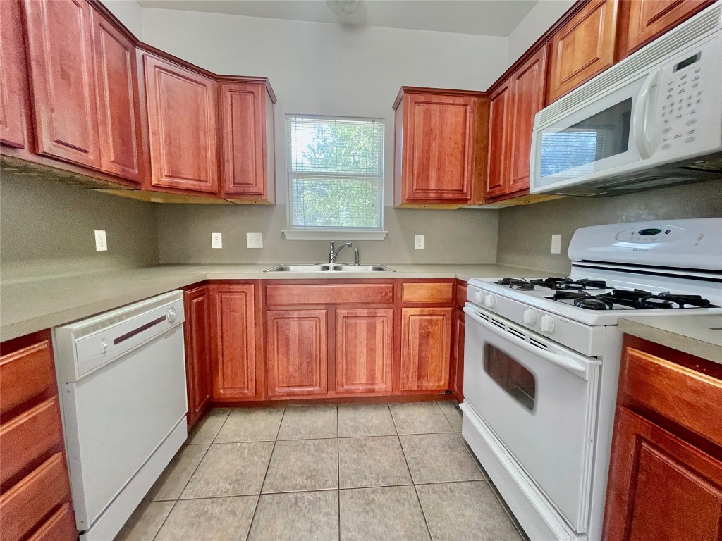 a kitchen with stainless steel appliances granite countertop a sink dishwasher stove and cabinets with wooden floor