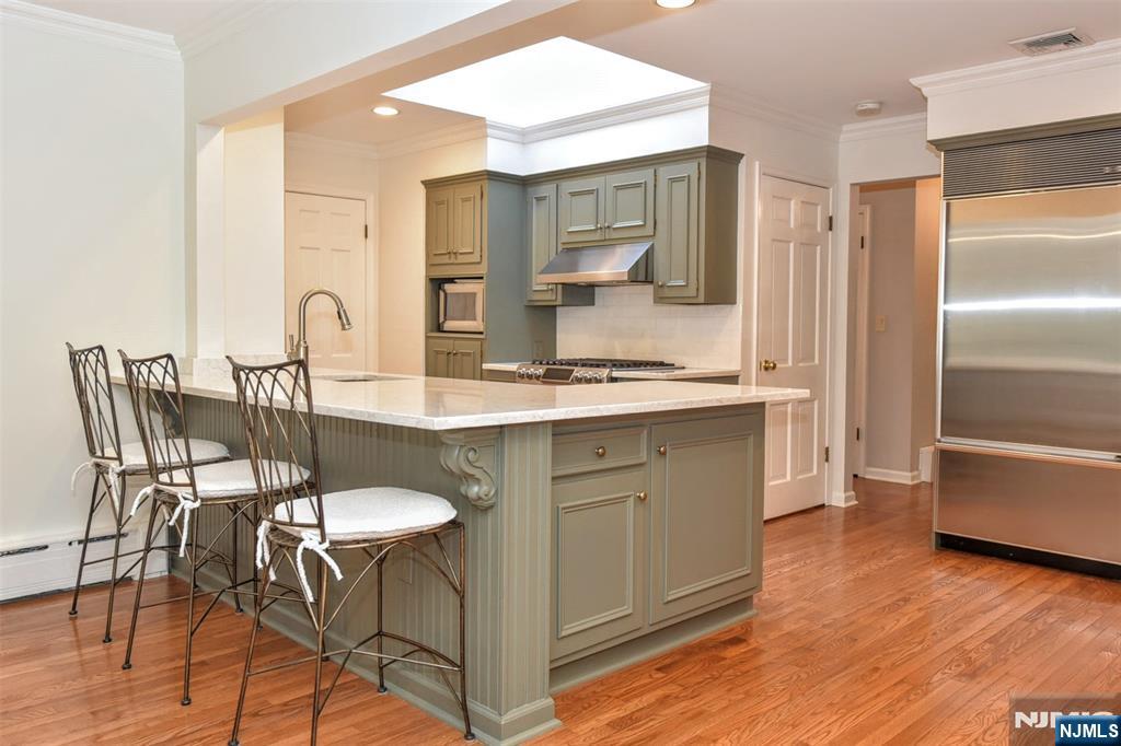 60 Dimmig Road Upper Saddle River, NJ 07458 - Photo 17 of 40 a kitchen with kitchen island granite countertop a table chairs sink and cabinets