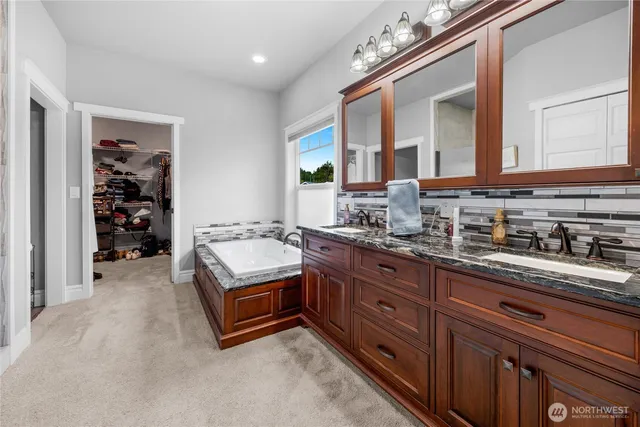 a spacious bathroom with a granite countertop double vanity