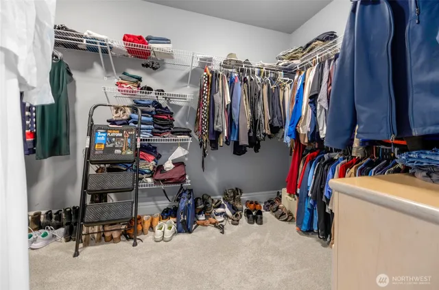 a view of walk in closet with clothes and shoes