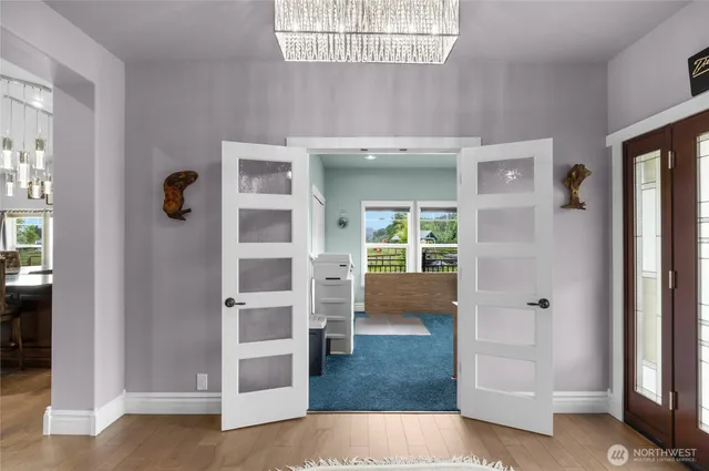 a view of a hallway with wooden floor and windows