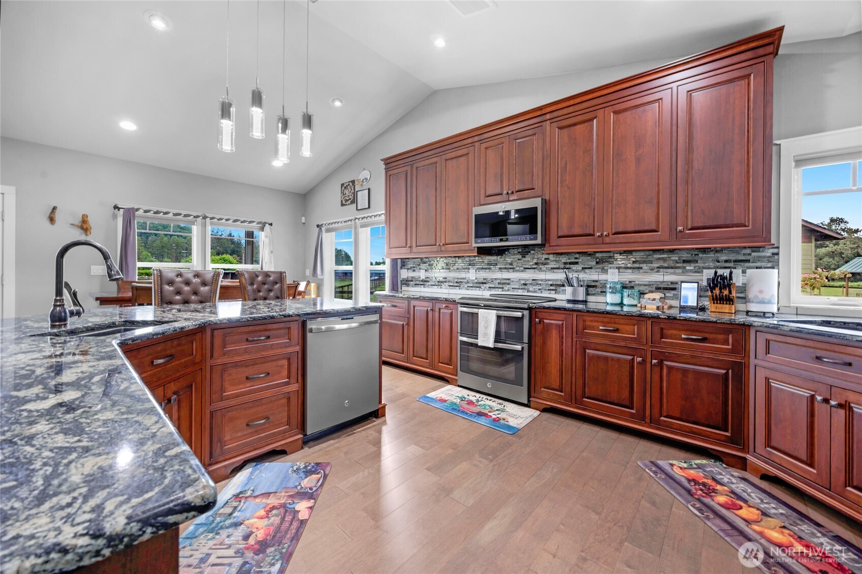 26812 162nd Street Southeast Monroe, WA 98272 - Photo 2 of 40 a large kitchen with stainless steel appliances granite countertop a stove a sink dishwasher a microwave oven and a dining table with wooden floor