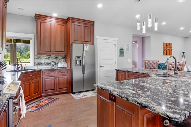 a kitchen with stainless steel appliances granite countertop a refrigerator and a sink