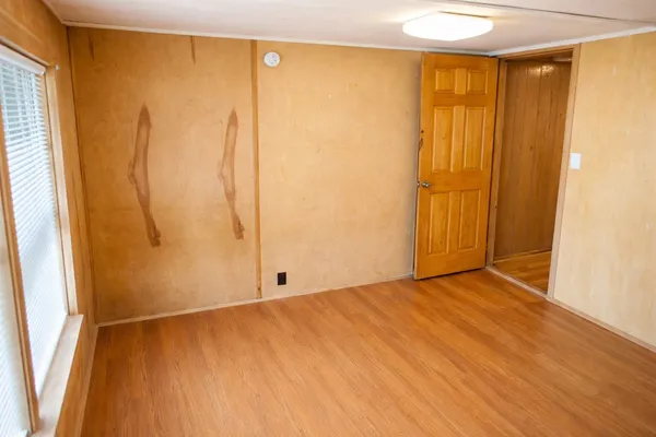 a view of an empty room with wooden floor