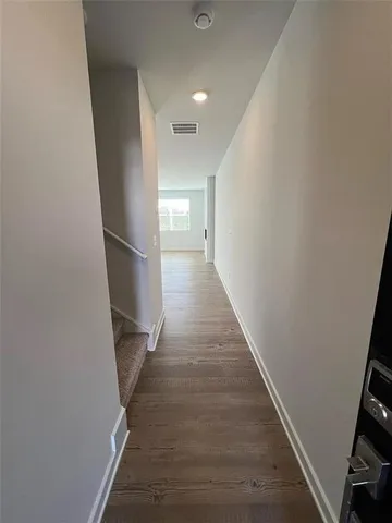 a view of a hallway with wooden floor and staircase