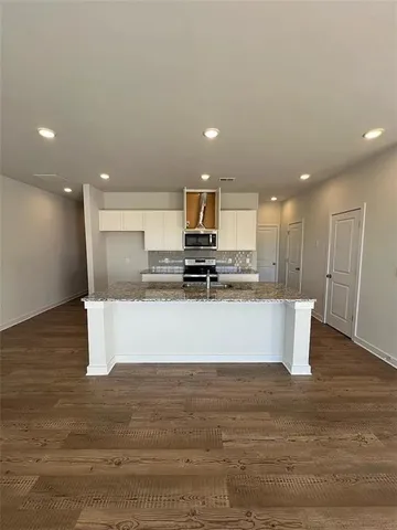 a view of kitchen with stainless steel appliances granite countertop refrigerator sink and stove