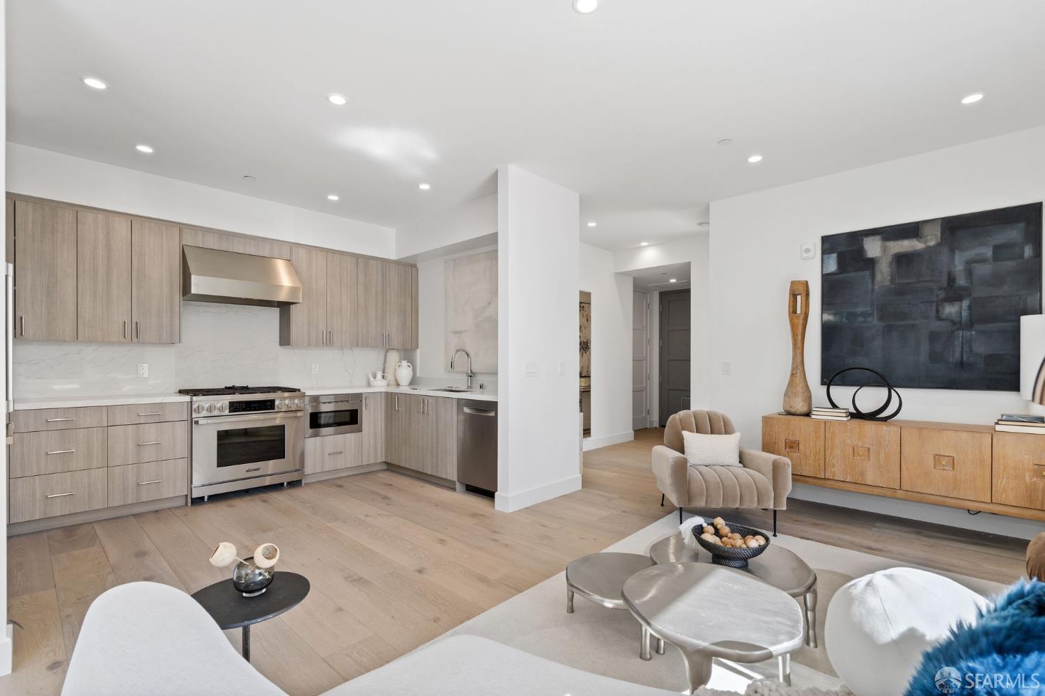 a living room with furniture a rug and kitchen view