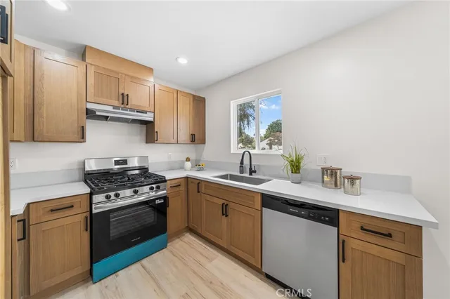 a kitchen with stainless steel appliances granite countertop a sink stove and cabinets