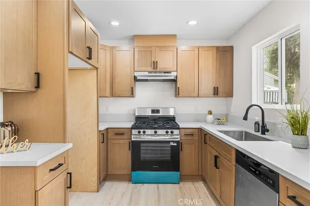 a kitchen with stainless steel appliances granite countertop a stove a sink dishwasher and a refrigerator