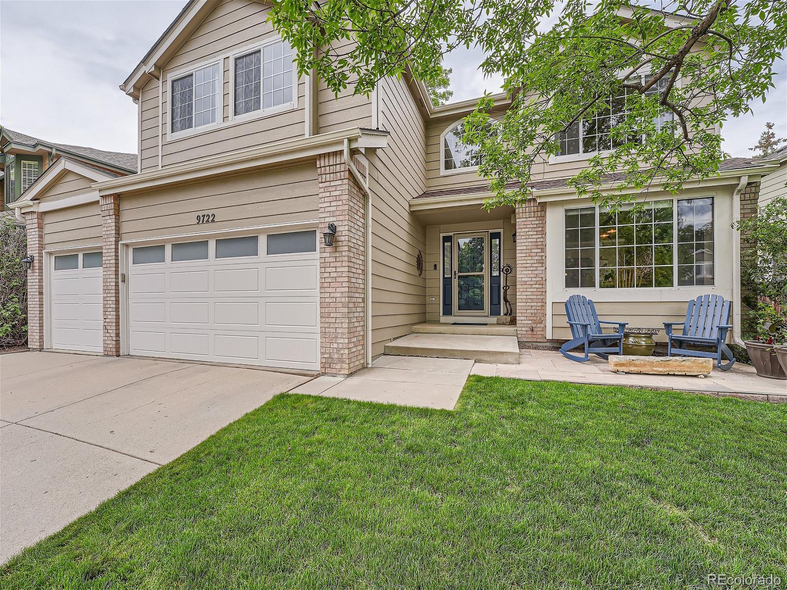 front view of a house with a yard and sitting area