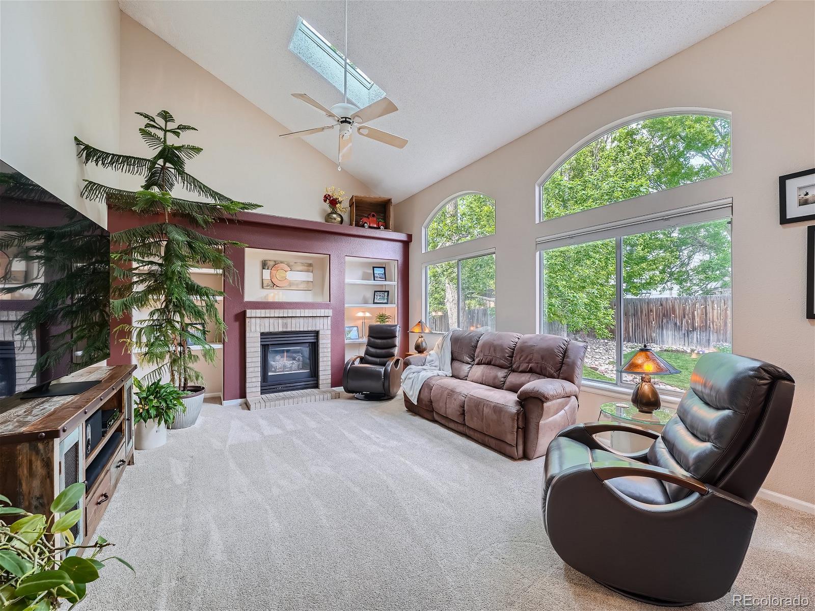 9722 Kipling Street Westminster, CO 80021 - Photo 14 of 37 a living room with furniture a fireplace and a flat screen tv