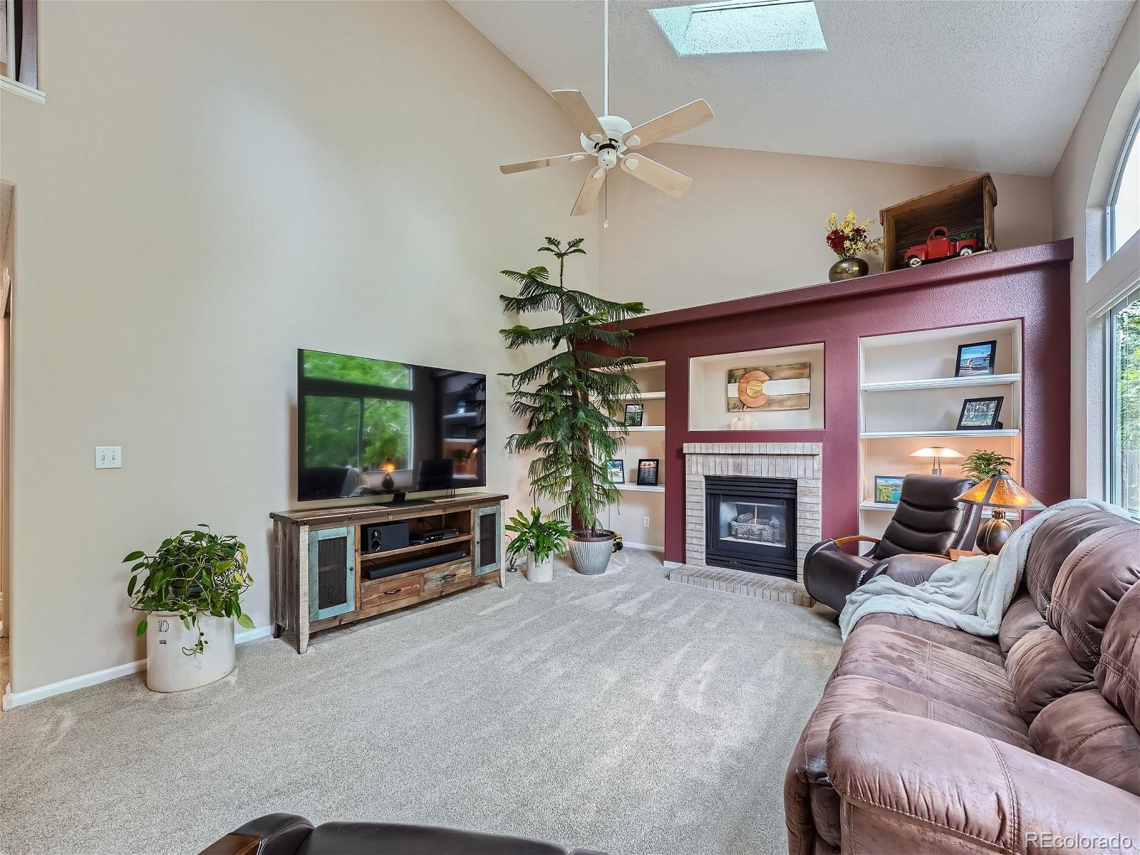9722 Kipling Street Westminster, CO 80021 - Photo 15 of 37 a living room with furniture a fireplace and a flat screen tv