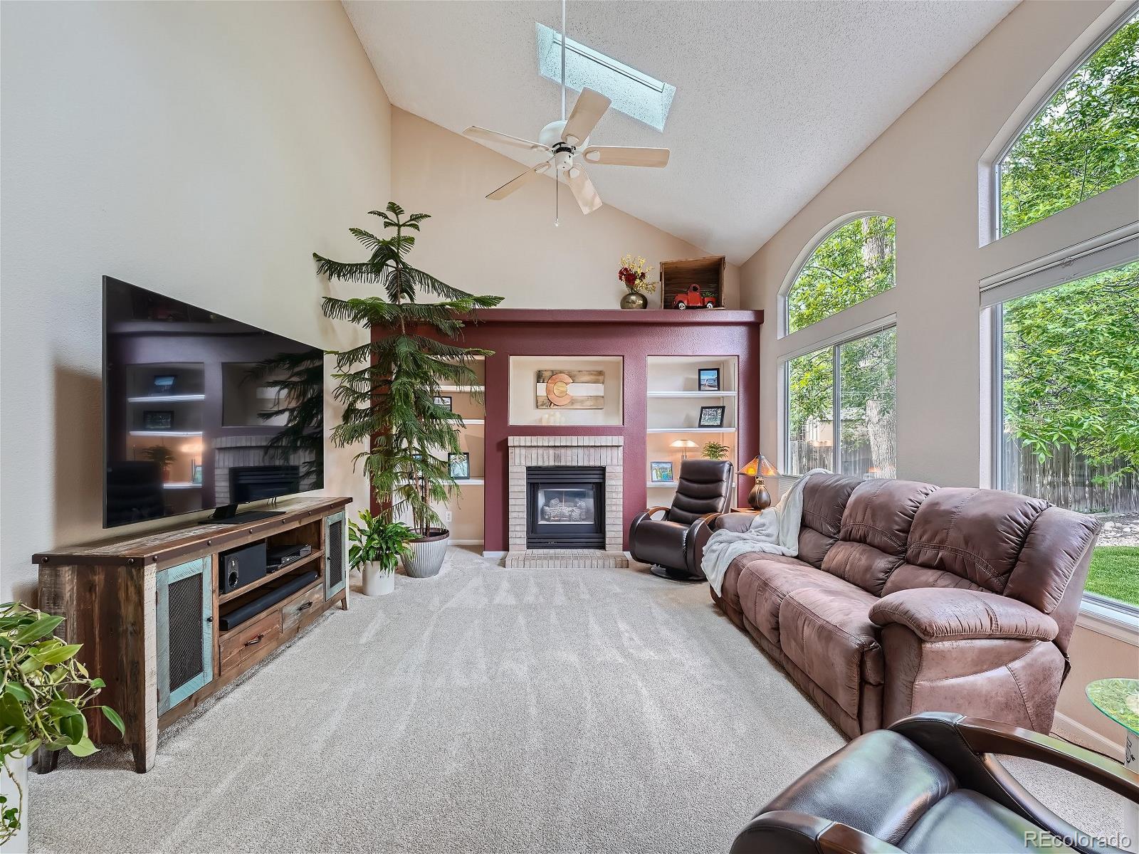 9722 Kipling Street Westminster, CO 80021 - Photo 17 of 37 a living room with furniture a fireplace and a flat screen tv