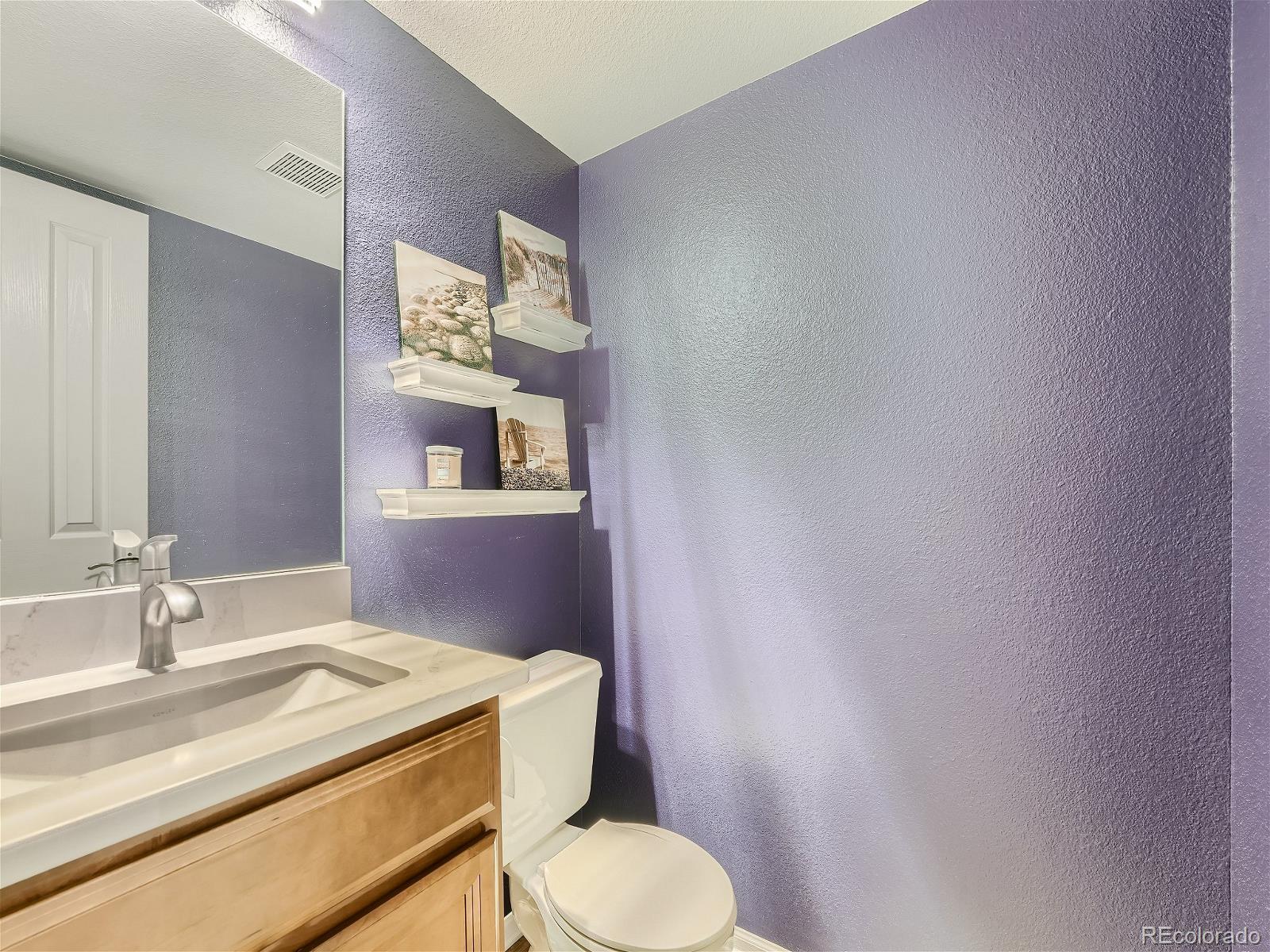 9722 Kipling Street Westminster, CO 80021 - Photo 18 of 37 a bathroom with a granite countertop sink mirror vanity and toilet