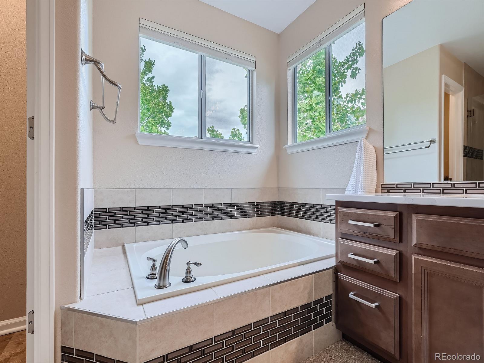 9722 Kipling Street Westminster, CO 80021 - Photo 23 of 37 a bathroom with a bathtub and window