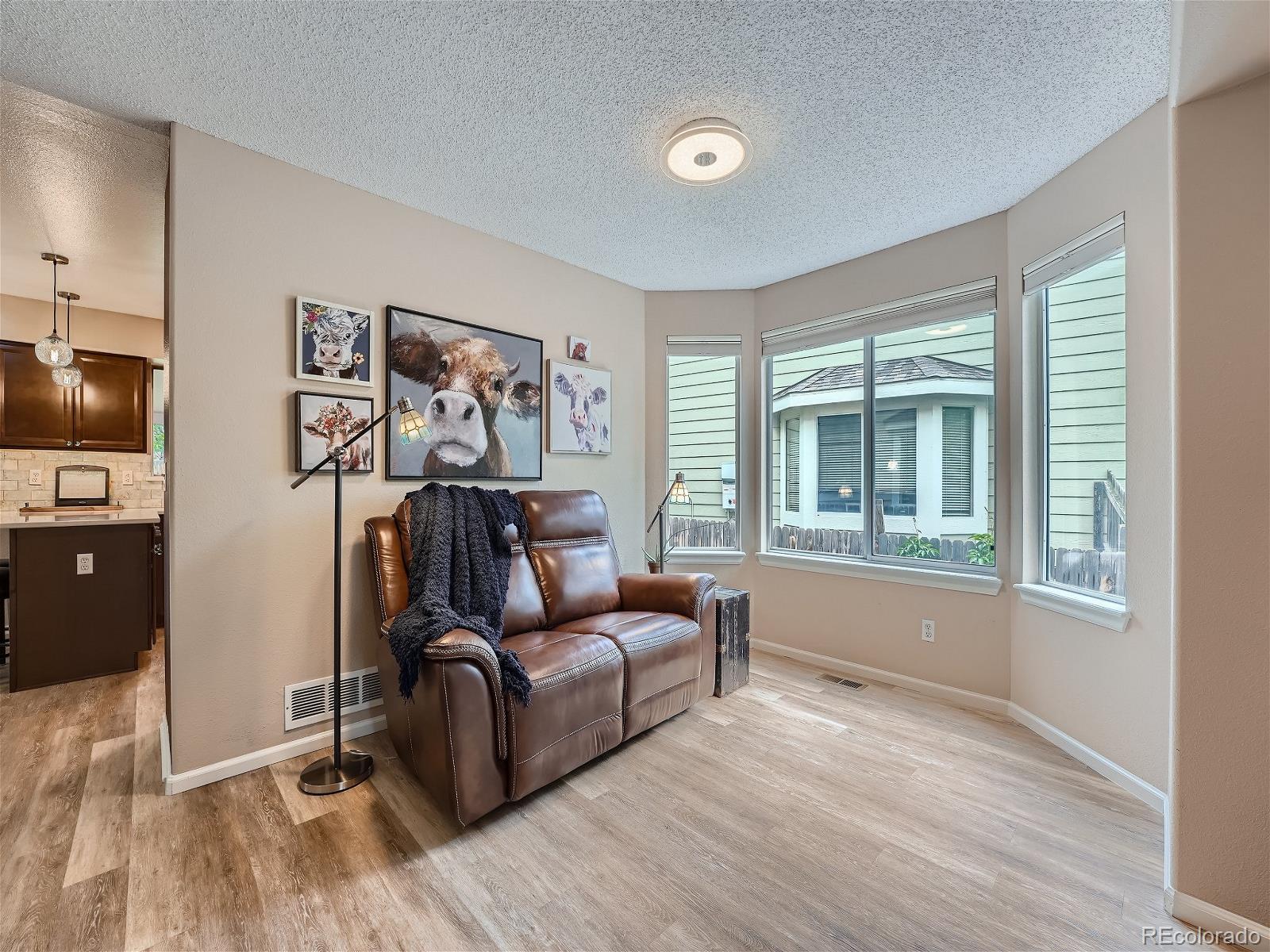 9722 Kipling Street Westminster, CO 80021 - Photo 6 of 37 a living room with furniture and a flat screen tv with wooden floor