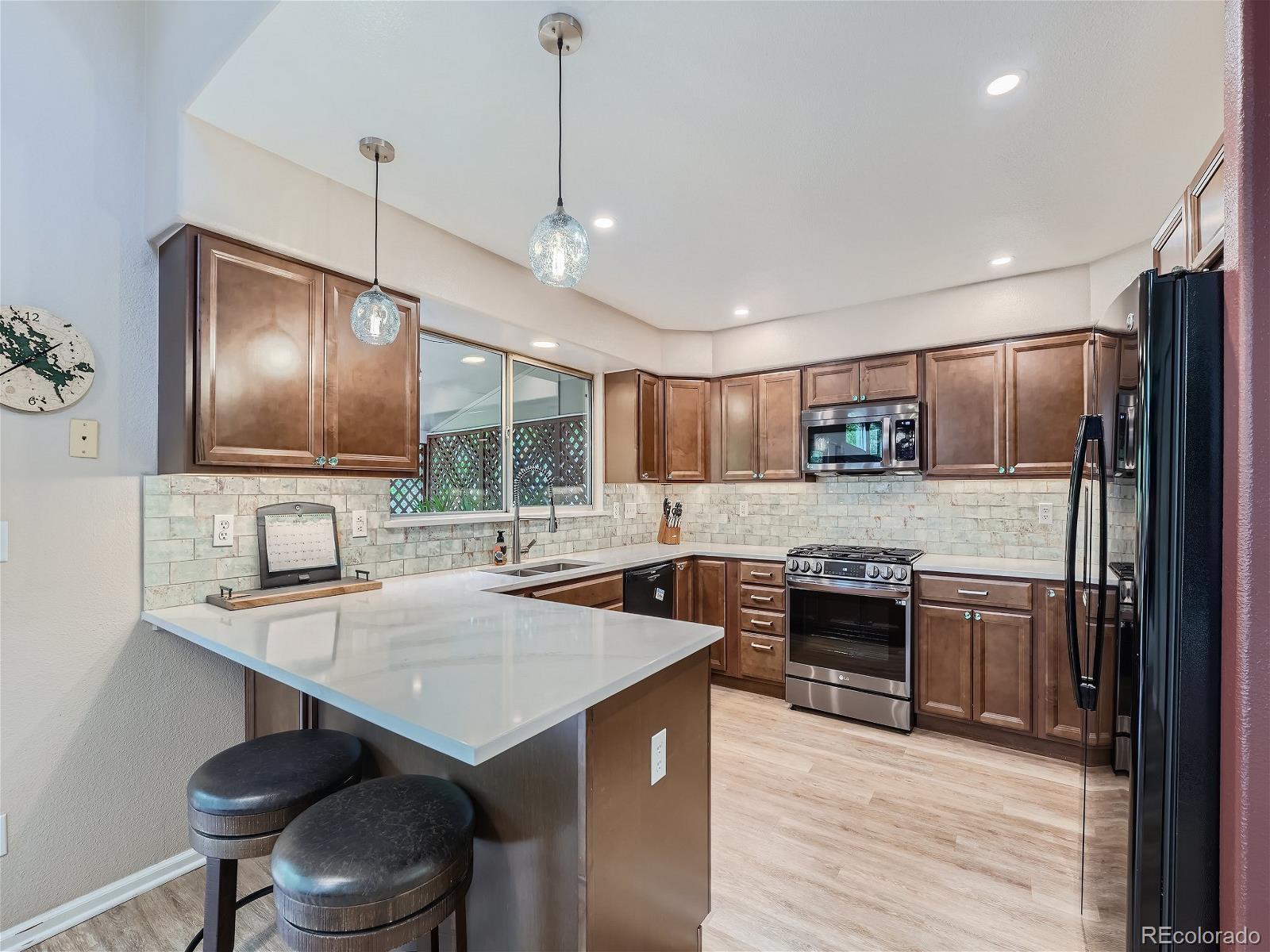 9722 Kipling Street Westminster, CO 80021 - Photo 8 of 37 a kitchen with stainless steel appliances granite countertop a stove refrigerator and cabinets