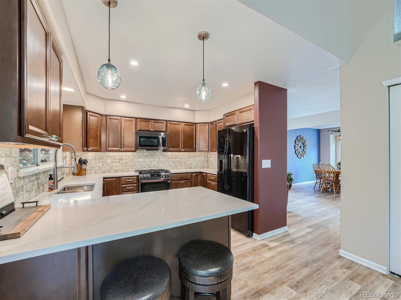 9722 Kipling Street Westminster, CO 80021 - Photo 9 of 37 a kitchen with stainless steel appliances a sink stove and refrigerator