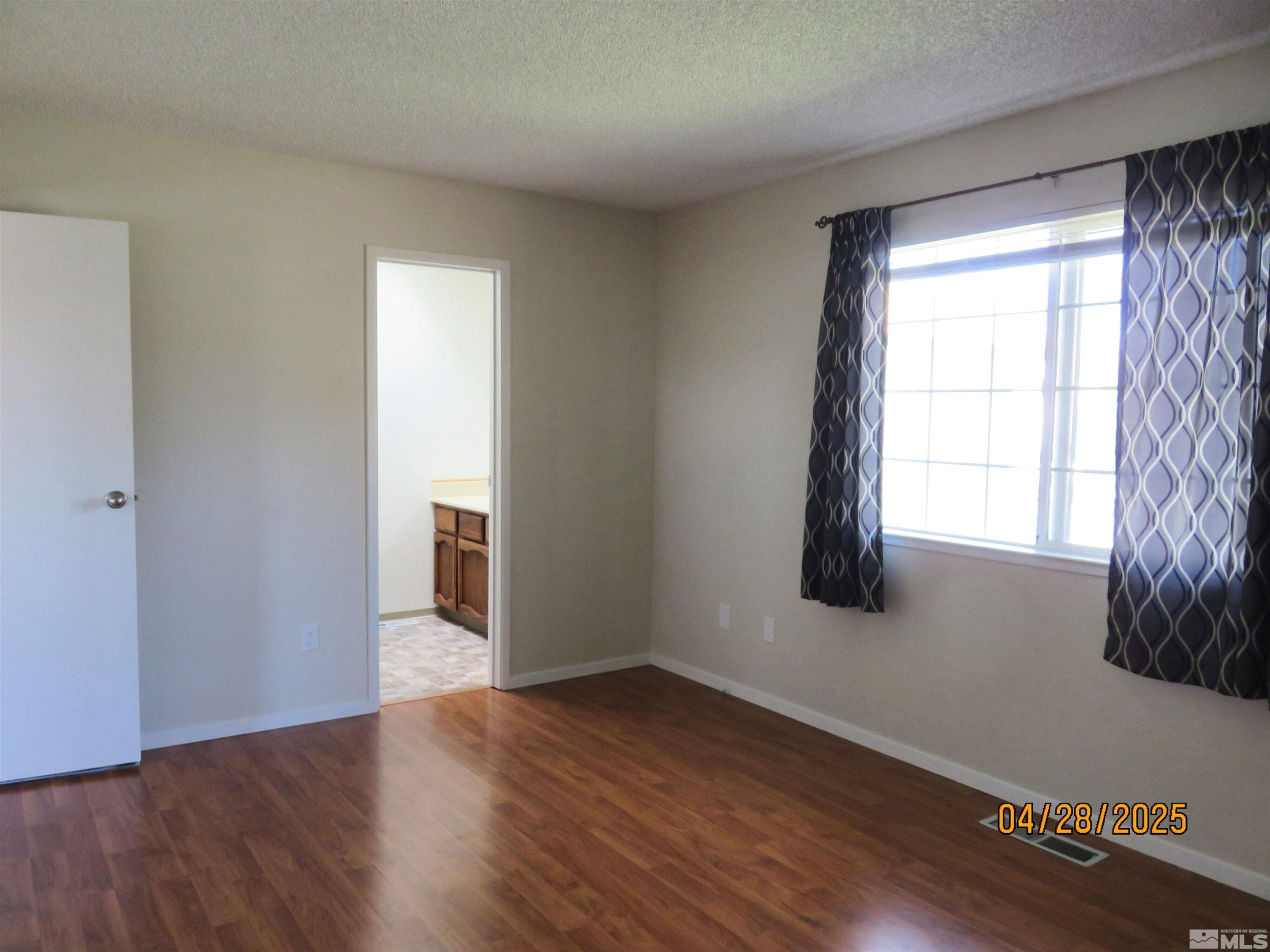 3973 Knoblock Road Carson City, NV 89706 - Photo 16 of 39 a view of an empty room with wooden floor and a window