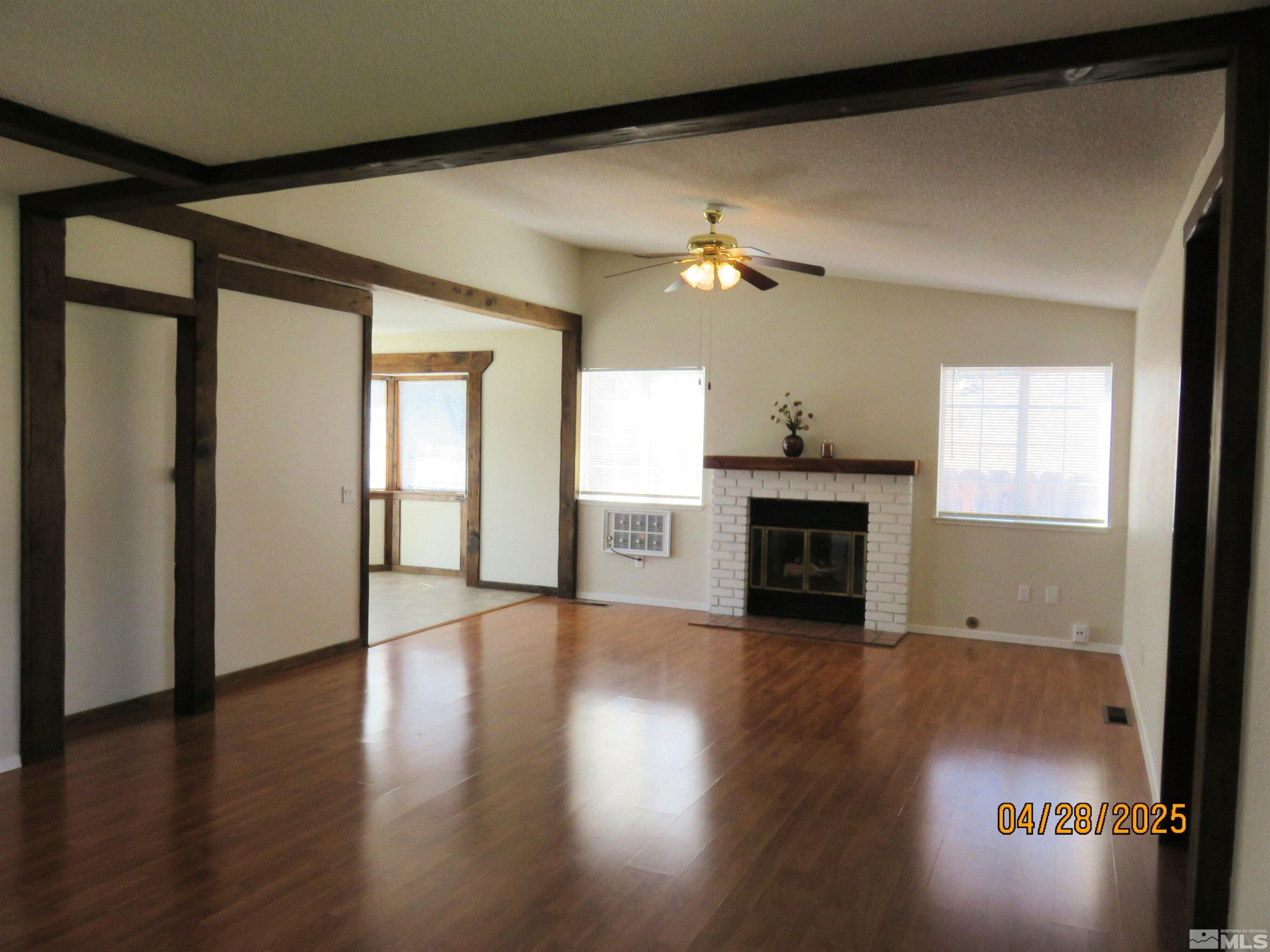 3973 Knoblock Road Carson City, NV 89706 - Photo 5 of 39 a view of a livingroom with a fireplace wooden floor and windows