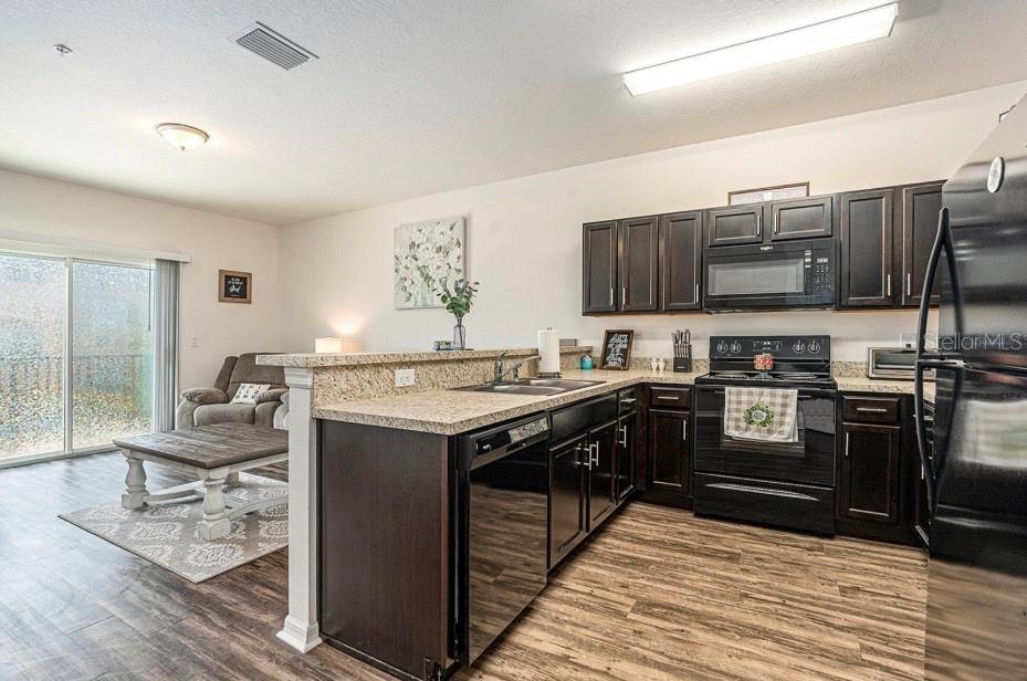 5521 Yellowfin Court New Port Richey, FL 34652 - Photo 7 of 23 a kitchen with stainless steel appliances granite countertop a stove and a sink