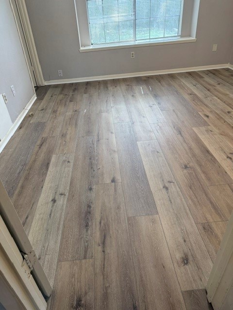 5102 Parsley Avenue Baytown, TX 77521 - Photo 16 of 19 an empty room with wooden floor and windows